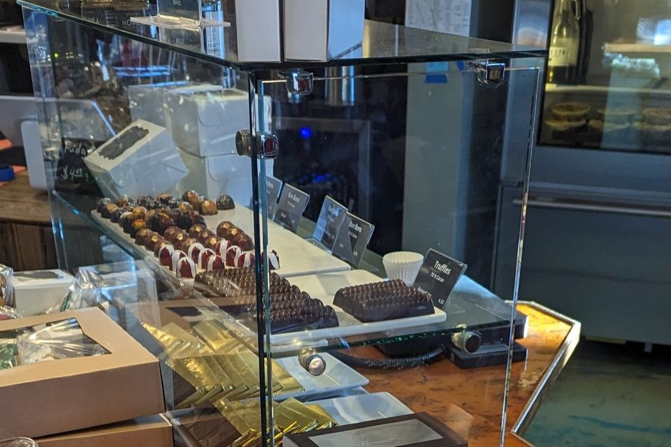 Handmade truffles and gold-wrapped chocolate bars in the chocolate case.