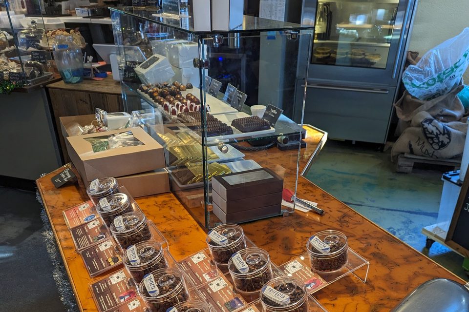 The truffle case beside sample jars of each roasted coffee on the copper counter.
